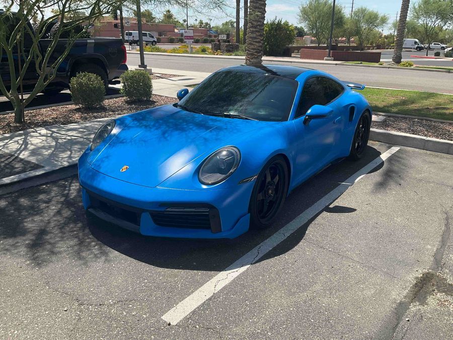 Satin blue wrapped Porsche 911 Turbo S parked in a lot
